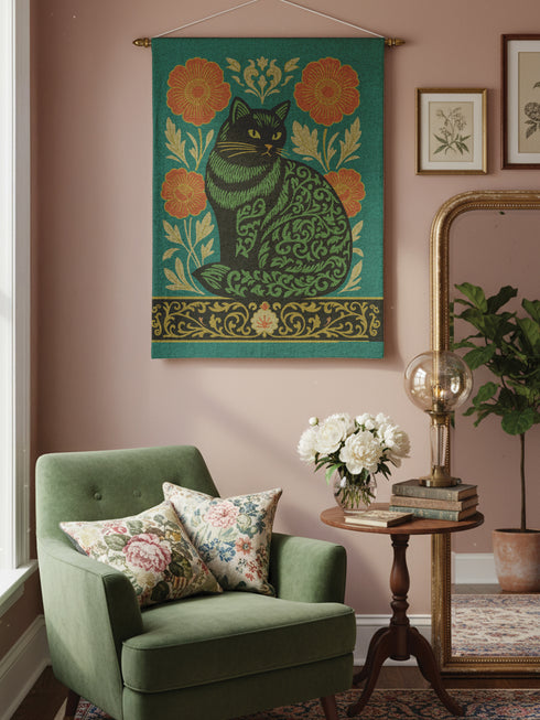 A rectangular woven wall tapestry featuring a stylized Art Nouveau black cat with intricate green scrollwork patterns on its body. The cat sits against a rich teal green background, flanked by two large, burnt-orange poppy flowers on golden stems. The design is symmetrical, with delicate botanical details. A decorative, ornate border in black, gold, and cream runs along the bottom. The textile has a visible, high-quality woven texture, blending polyester and cotton threads.